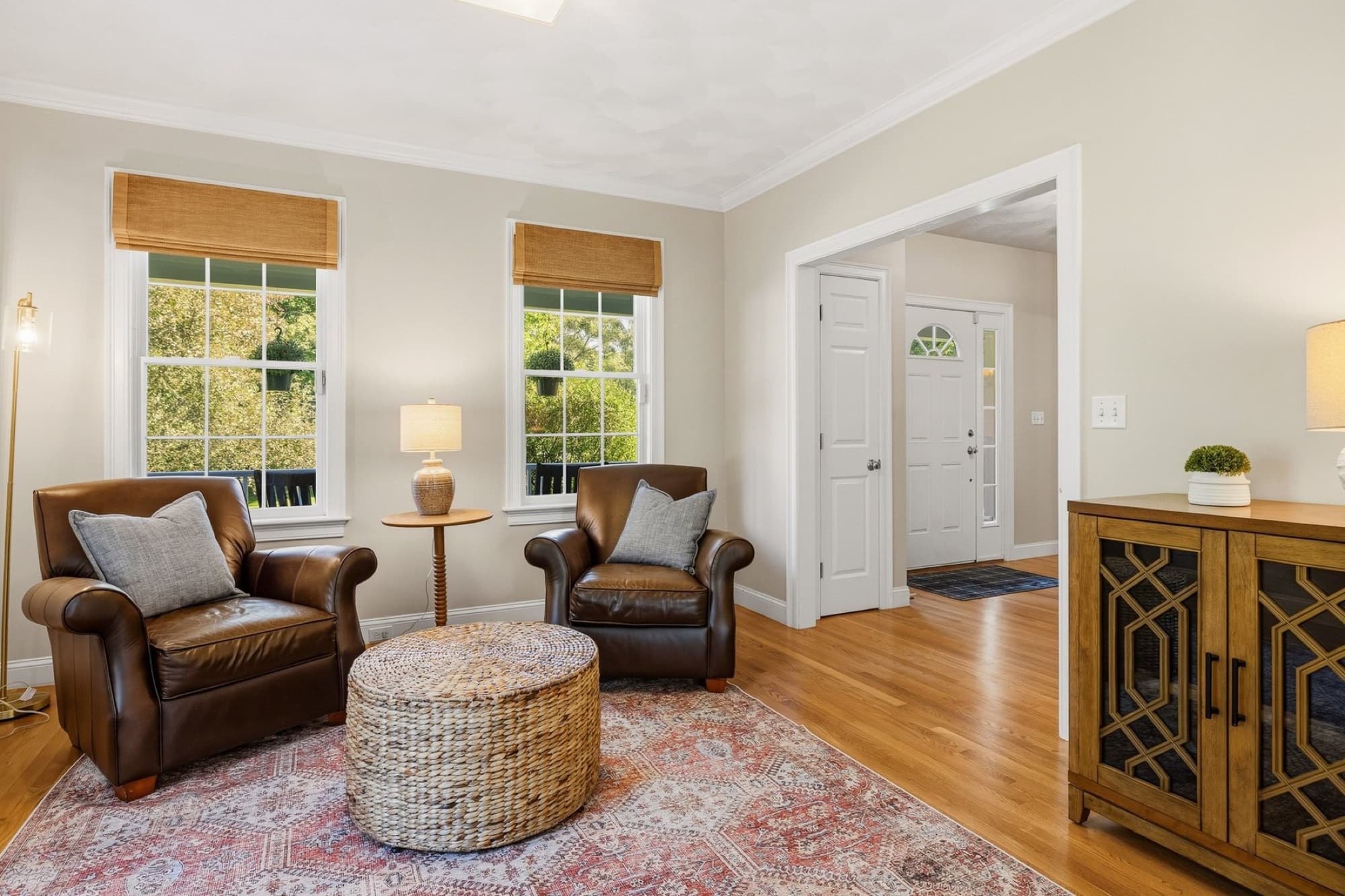 The family room with 2 windows, a pair of leather chairs, and French doors to the foyer